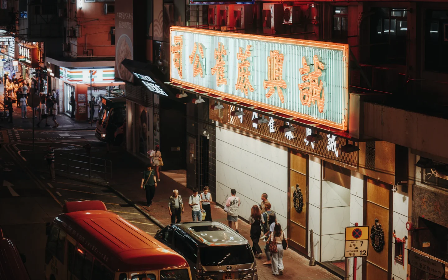 Phố đêm đông người với nhiều biển neon màu sắc