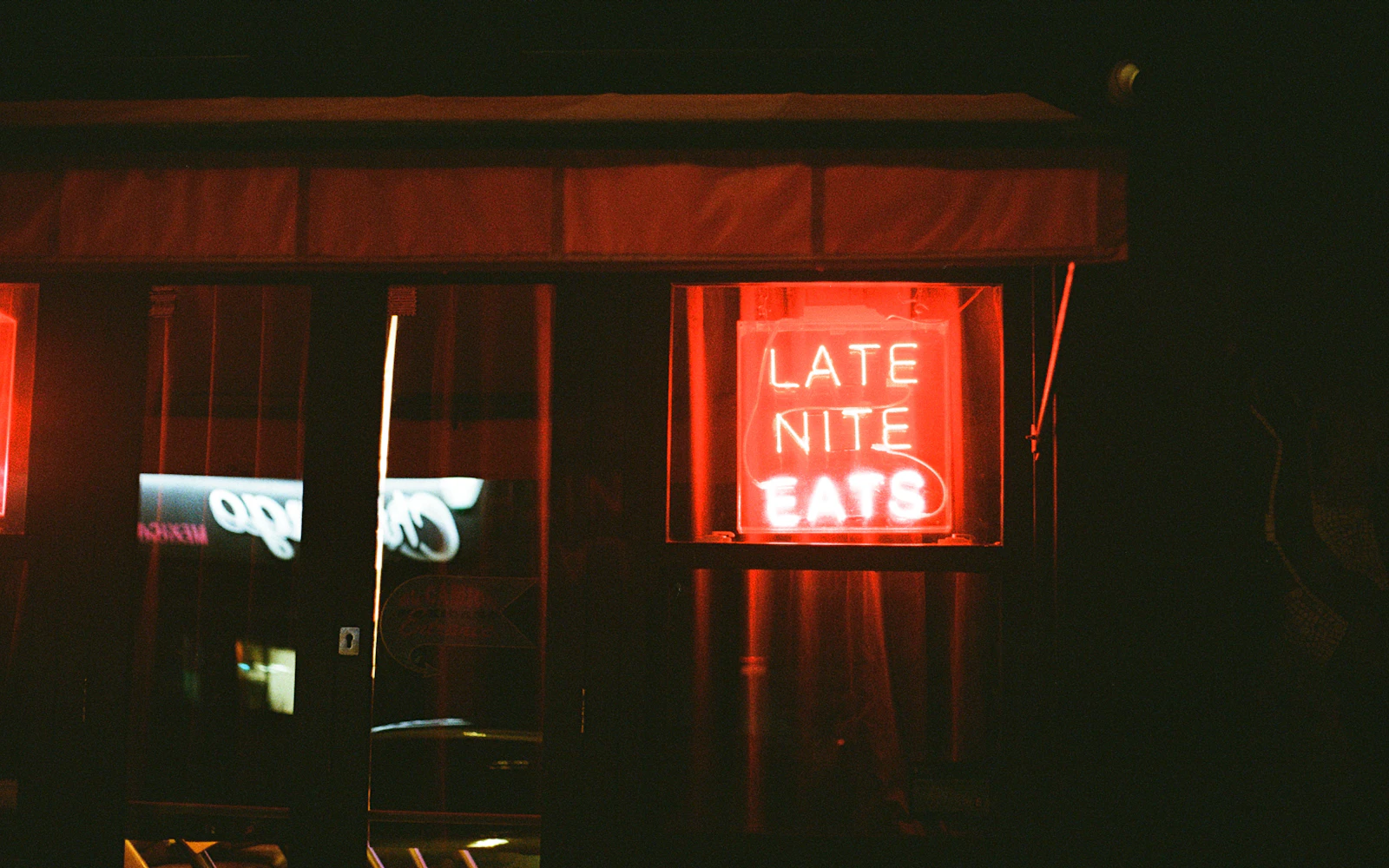 Biển neon Late Night Eats nổi bật giữa bóng tối